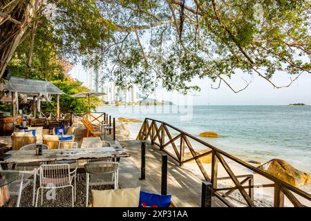 Tables et chaises dans un restaurant avec vue sur la plage de Tanjing Tokong à Penang, Malaisie Banque D'Images