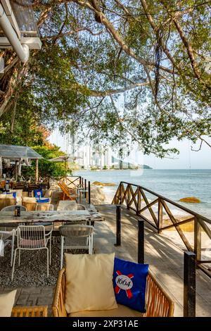 Tables et chaises dans un restaurant avec vue sur la plage de Tanjing Tokong à Penang, Malaisie Banque D'Images