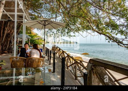 Une famille s'est assise à une table dans un restaurant avec vue sur la plage de Tanjing Tokong à Penang, en Malaisie Banque D'Images