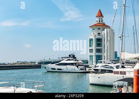 Le phare moderne se trouve au bout de la marina du détroit à Tanjung Tokong à Penang, en Malaisie avec des bateaux de plaisance amarrés devant. Banque D'Images