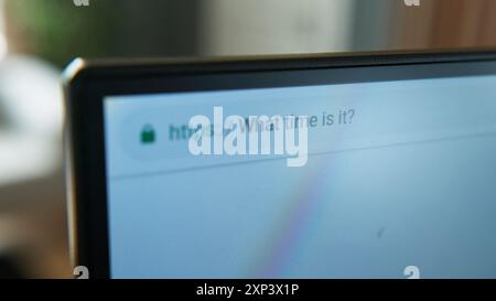 Gros plan d'un écran d'ordinateur affichant la requête de recherche « quelle heure est-il ? ». Outils numériques pour une information rapide, démontrant l'omniprésent Banque D'Images