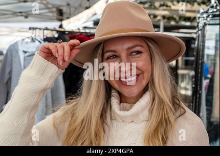 Une jeune fille de Tasmanie qui dirige un magasin de chapeaux australien traditionnel au marché hebdomadaire de la ville un samedi le long de Salamanca place à Hobart, Tasmanie, Banque D'Images