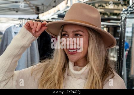 Une jeune fille de Tasmanie qui dirige un magasin de chapeaux australien traditionnel au marché hebdomadaire de la ville un samedi le long de Salamanca place à Hobart, Tasmanie, Banque D'Images