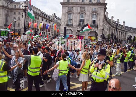 Londres, Royaume-Uni. 03 août 2024. Les manifestants tiennent des drapeaux palestiniens pendant la marche à Piccadilly Circus. Des milliers de personnes ont défilé en solidarité avec la Palestine pour exiger un cessez-le-feu et appeler le gouvernement britannique à cesser d’armer Israël alors que la guerre à Gaza se poursuit. Crédit : SOPA images Limited/Alamy Live News Banque D'Images