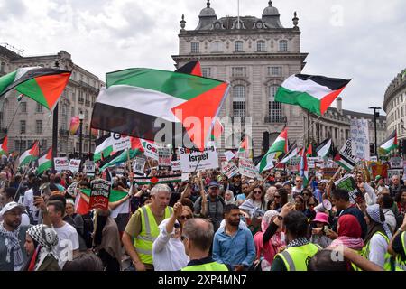 Londres, Royaume-Uni. 03 août 2024. Les manifestants tiennent des drapeaux palestiniens pendant la marche à Piccadilly Circus. Des milliers de personnes ont défilé en solidarité avec la Palestine pour exiger un cessez-le-feu et appeler le gouvernement britannique à cesser d’armer Israël alors que la guerre à Gaza se poursuit. Crédit : SOPA images Limited/Alamy Live News Banque D'Images