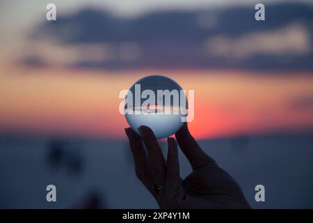 Main de femme avec boule de cristal Sunset Banque D'Images