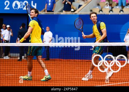 Paris, France, 3 août 2024. Matthew Eden et John Peers d'Australie embrassent drapés dans l'australien lancer des balles de tennis dans la foule après avoir remporté l'or lors des Jeux Olympiques de Paris 2024 Tennis MenÕs double final entre Eden/Peers d'Australie et Krajicek/Ram des États-Unis au stade Roland-Garros le 3 août 2024 à Paris, France. Crédit : Pete Dovgan/Speed Media/Alamy Live News Banque D'Images