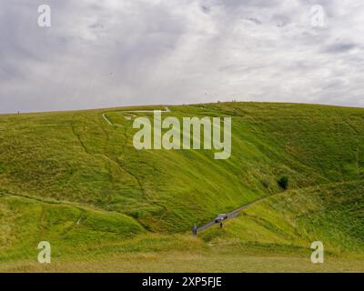 Figure de colline de cheval blanc d'Uffington avec des touristes au sommet et marchant le long des sentiers de Dragon Hill à Uffington, Oxfordshire, Angleterre, Royaume-Uni Banque D'Images