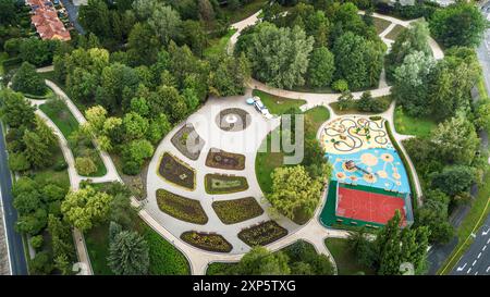 Vue aérienne d'un magnifique parc urbain avec aire de jeux et espaces de jardin au printemps Banque D'Images