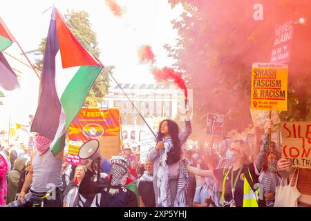 Leeds, Royaume-Uni. 03 AOÛT 2024. La jeune fille tient une fusée rouge et le drapeau palestinien comme protestataires à la fois à gauche et à droite du spectre rassemblé à Leeds. Une importante Assemblée de droite auto-identifiante d'environ 200 personnes s'est réunie avec une contre-manifestation de la SUTR, ainsi que des militants de la marche hebdomadaire Pro Palestine. La droite a marché brièvement dans le centre de Leeds et une arrestation a été notée. Crédit Milo Chandler/Alamy Live News Banque D'Images