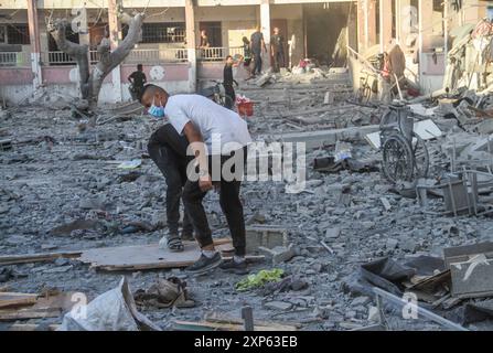 Gaza. 3 août 2024. Des Palestiniens inspectent l’école Hamama attaquée par des avions de guerre israéliens dans le quartier de Sheikh Radwan au Nord de la ville de Gaza, le 3 août 2024. Au moins 15 Palestiniens ont été tués et des dizaines d'autres blessés par une frappe aérienne israélienne sur une école dans le quartier de Sheikh Radwan dans la ville de Gaza samedi, a déclaré le Hamas. Crédit : Mahmoud Zaki/Xinhua/Alamy Live News Banque D'Images