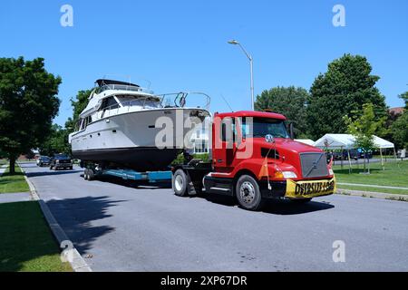 Camion lourd remorquant un grand bateau à l'eau Banque D'Images