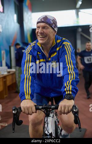 Joyeux vétéran ukrainien cycliste sur un vélo pendant le défi Invictus Games à Kiev - 13 décembre,2023 Banque D'Images