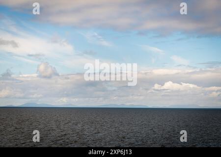 Une image HDR d'été nuageuse prise du ferry Uig-Lochmaddy traversant le Little Minch entre l'île de Skye et les Hébrides extérieures, en Écosse Banque D'Images