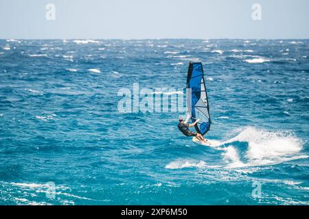 Algajola, Corse, France - 31 mai 2024 : un windsurfeur attaque de fortes vagues au large d'Aregno plage à Algajola sur la côte méditerranéenne de l'île Banque D'Images