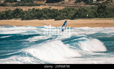 Algajola, Corse, France - 31 mai 2024 : un windsurfeur attaque de fortes vagues au large d'Aregno plage à Algajola sur la côte méditerranéenne de l'île Banque D'Images