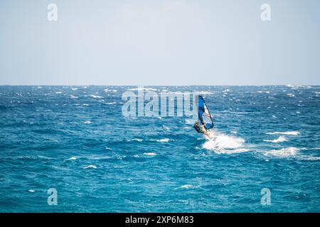 Algajola, Corse, France - 31 mai 2024 : un windsurfeur attaque de fortes vagues au large d'Aregno plage à Algajola sur la côte méditerranéenne de l'île Banque D'Images