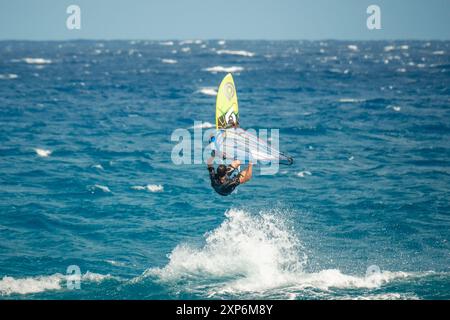 Algajola, Corse, France - 31 mai 2024 : un windsurfeur prend les airs au-dessus de fortes vagues au large d'Aregno plage à Algajola sur la côte méditerranéenne Banque D'Images