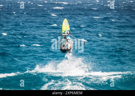 Algajola, Corse, France - 31 mai 2024 : un windsurfeur prend les airs au-dessus de fortes vagues au large d'Aregno plage à Algajola sur la côte méditerranéenne Banque D'Images