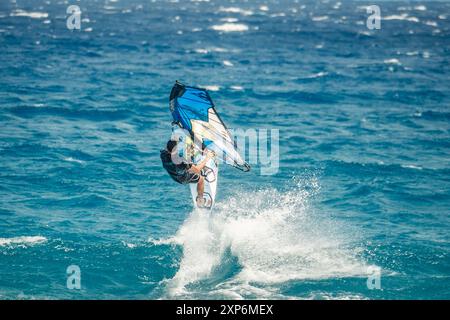 Algajola, Corse, France - 31 mai 2024 : un windsurfeur prend les airs au-dessus de fortes vagues au large d'Aregno plage à Algajola sur la côte méditerranéenne Banque D'Images