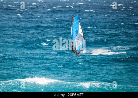 Algajola, Corse, France - 31 mai 2024 : un windsurfeur attaque de fortes vagues au large d'Aregno plage à Algajola sur la côte méditerranéenne de l'île Banque D'Images