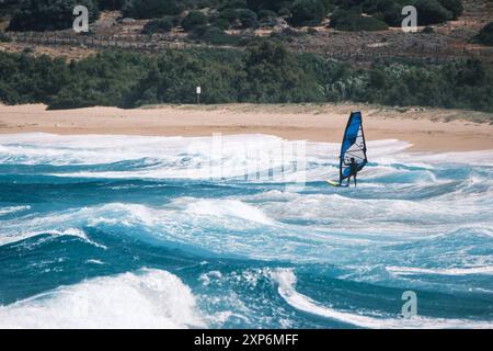 Algajola, Corse, France - 31 mai 2024 : un windsurfeur attaque de fortes vagues au large d'Aregno plage à Algajola sur la côte méditerranéenne de l'île Banque D'Images