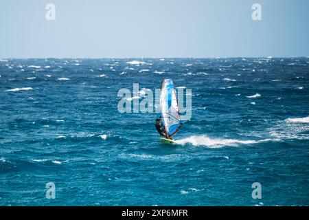 Algajola, Corse, France - 31 mai 2024 : un windsurfeur attaque de fortes vagues au large d'Aregno plage à Algajola sur la côte méditerranéenne de l'île Banque D'Images