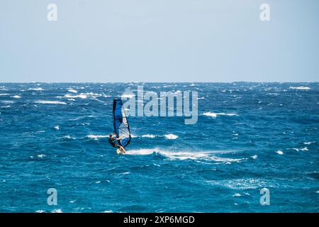 Algajola, Corse, France - 31 mai 2024 : un windsurfeur attaque de fortes vagues au large d'Aregno plage à Algajola sur la côte méditerranéenne de l'île Banque D'Images