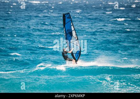 Algajola, Corse, France - 31 mai 2024 : un windsurfeur attaque de fortes vagues au large d'Aregno plage à Algajola sur la côte méditerranéenne de l'île Banque D'Images