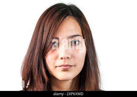 Portrait de tête d'une jeune femme asiatique regardant directement dans l'appareil photo sur fond blanc. Banque D'Images