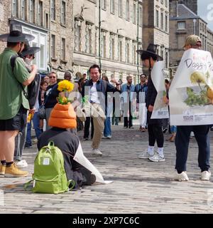 Jouer dans la rue avec un objet et porter des chapeaux de fantaisie pendant le Festival Fringe d'Édimbourg, le 3 août 2024 Banque D'Images