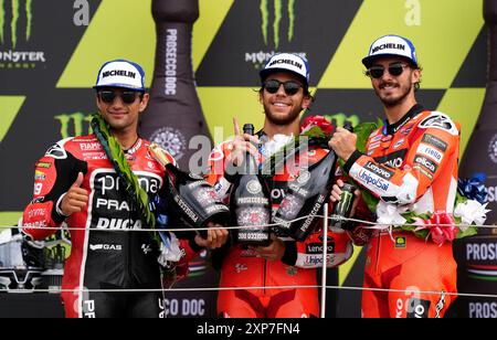 Enea Bastianini de l'écurie Ducati Lenovo (au centre) Jorge Martin de Prima Pramac Racing (à gauche) et Francesco Bagnaia (à droite) célèbrent sur le podium après le Monster Energy British Grand Prix MotoGP 2024 à Silverstone, Towcester. Date de la photo : dimanche 4 août 2024. Banque D'Images