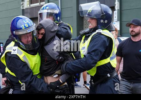 La police arrête un homme lors d'une manifestation contre l'immigration au cénotaphe Middlesbrough à Albert Park, Middlesbrough. Date de la photo : dimanche 4 août 2024. Banque D'Images