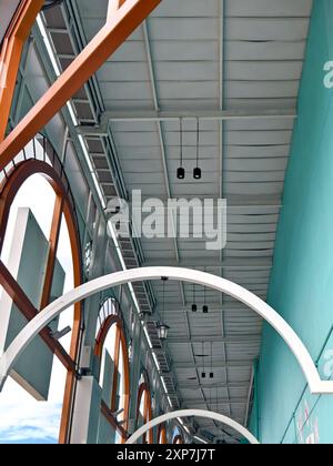 Bâtiment blanc avec fenêtres cintrées, garniture bleue, se dresse haut sous le ciel clair Banque D'Images