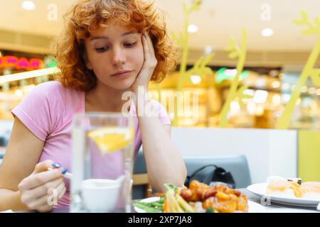 attirante rousse adolescente mangeant de la soupe chinoise dans un restaurant de restauration rapide Banque D'Images