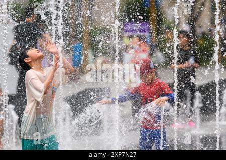 Séoul, Corée du Sud. 4 août 2024. Des enfants sud-coréens jouent dans l'eau par un après-midi chaud à la fontaine de la place Gwanghwamun. Avec l’alerte de vague de chaleur en vigueur en Corée du Sud, la température à Yeoju, à 64 kilomètres au sud-est de Séoul, a atteint 40 degrés Celsius le 4 août, la température la plus élevée depuis 2018. L'Administration météorologique sud-coréenne a prédit que la vague de chaleur se poursuivra pendant une semaine jusqu'au 14 août, car les températures diurnes resteront au-dessus de la normale, y compris 30 degrés Celsius et 36 degrés Celsius dans tout le pays. Banque D'Images