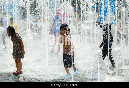 Séoul, Corée du Sud. 4 août 2024. Des enfants sud-coréens jouent dans l'eau par un après-midi chaud à la fontaine de la place Gwanghwamun. Avec l’alerte de vague de chaleur en vigueur en Corée du Sud, la température à Yeoju, à 64 kilomètres au sud-est de Séoul, a atteint 40 degrés Celsius le 4 août, la température la plus élevée depuis 2018. L'Administration météorologique sud-coréenne a prédit que la vague de chaleur se poursuivra pendant une semaine jusqu'au 14 août, car les températures diurnes resteront au-dessus de la normale, y compris 30 degrés Celsius et 36 degrés Celsius dans tout le pays. Banque D'Images