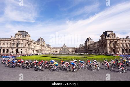 Le peloton passe devant le Musée du Louvre lors de la course cycliste féminine sur route, le neuvième jour des Jeux Olympiques de Paris 2024 en France. Date de la photo : dimanche 4 août 2024. Banque D'Images