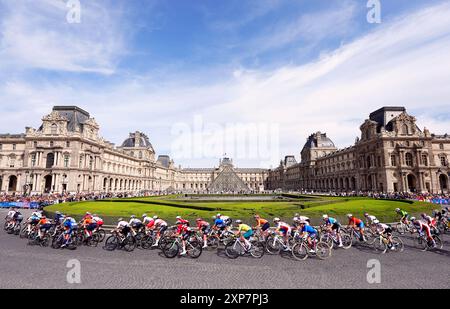 Le peloton passe devant le Musée du Louvre lors de la course cycliste féminine sur route, le neuvième jour des Jeux Olympiques de Paris 2024 en France. Date de la photo : dimanche 4 août 2024. Banque D'Images