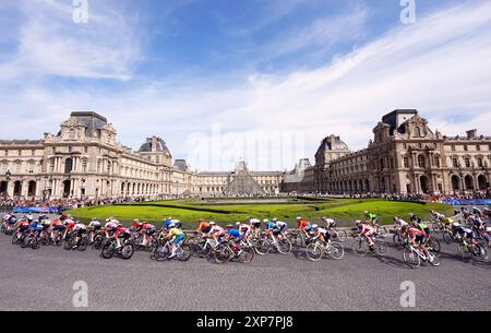 Le peloton passe devant le Musée du Louvre lors de la course cycliste féminine sur route, le neuvième jour des Jeux Olympiques de Paris 2024 en France. Date de la photo : dimanche 4 août 2024. Banque D'Images