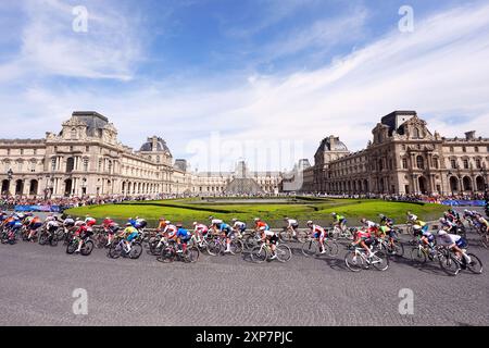 Le peloton passe devant le Musée du Louvre lors de la course cycliste féminine sur route, le neuvième jour des Jeux Olympiques de Paris 2024 en France. Date de la photo : dimanche 4 août 2024. Banque D'Images