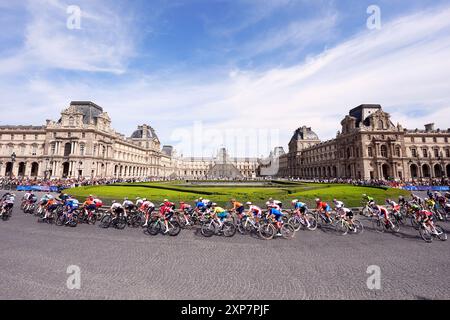 Le peloton passe devant le Musée du Louvre lors de la course cycliste féminine sur route, le neuvième jour des Jeux Olympiques de Paris 2024 en France. Date de la photo : dimanche 4 août 2024. Banque D'Images