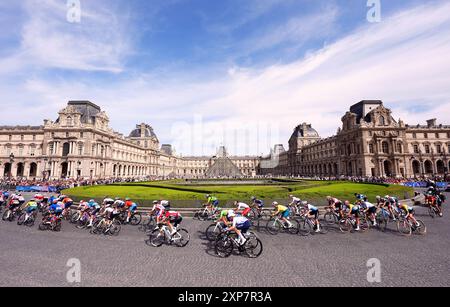 Le peloton passe devant le Musée du Louvre lors de la course cycliste féminine sur route, le neuvième jour des Jeux Olympiques de Paris 2024 en France. Date de la photo : dimanche 4 août 2024. Banque D'Images