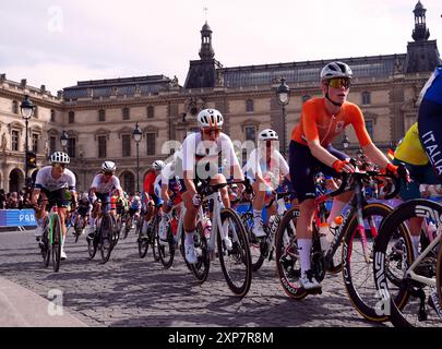 Le peloton passe devant le Musée du Louvre lors de la course cycliste féminine sur route, le neuvième jour des Jeux Olympiques de Paris 2024 en France. Date de la photo : dimanche 4 août 2024. Banque D'Images