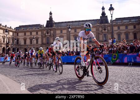 Le peloton passe devant le Musée du Louvre lors de la course cycliste féminine sur route, le neuvième jour des Jeux Olympiques de Paris 2024 en France. Date de la photo : dimanche 4 août 2024. Banque D'Images