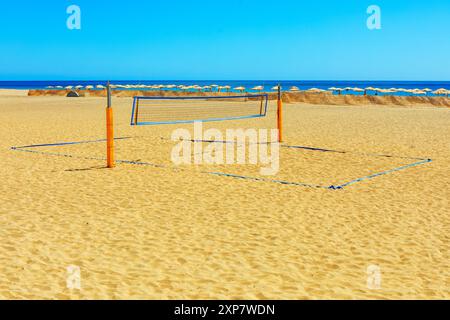 Un filet de volley-ball est installé sur une plage de sable. Filet de volley-ball sur la côte avec l'océan en arrière-plan Banque D'Images