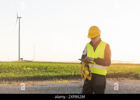 Ingénieur avec tablette numérique contrôle les éoliennes. Banque D'Images