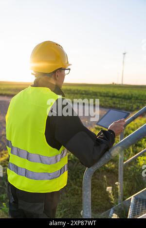 Ingénieur avec tablette numérique contrôle les éoliennes. Banque D'Images