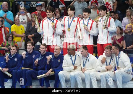 Paris, France. 04 août 2024. L'équipe chinoise de relais masculin 4 x 100 m célèbre la victoire de la médaille d'or avec les médaillés d'argent des États-Unis, à gauche, et les médaillés de bronze de France, à droite, lors des Jeux Olympiques de Paris 2024 à la Defense Arena à Paris, France, le dimanche 4 août 2024. Photo de Richard Ellis/UPI crédit : UPI/Alamy Live News Banque D'Images