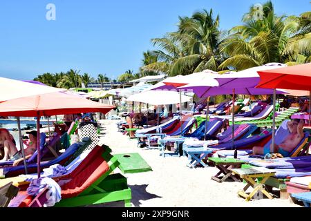 Touristes appréciant secret Beach à San Pedro, Belize. Les gens se relaxent dans des chaises longues sur le sable en été. Banque D'Images